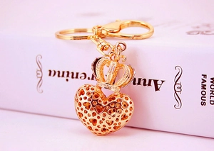 Macro detail of golden crown heart keychain with lobster clasp and metal ring