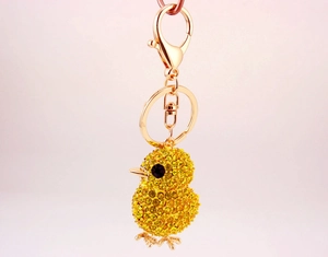Close-up of yellow rhinestone chick keychain with golden lobster clasp and key ring detail