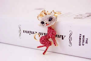 Macro detail of a golden cat keychain with sparkling clear and red rhinestones