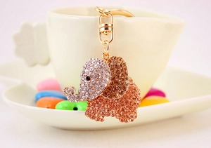 Close-up of golden elephant keychain with sparkling brown rhinestones on a teacup