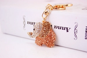 Close-up of golden elephant keychain with sparkling crystal rhinestones on white prop book