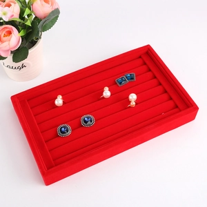 Macro detail of red velvet jewelry display tray for rings and stud earrings