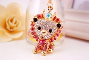Close-up of diamond-encrusted lion keychain with crown detail and colorful crystals