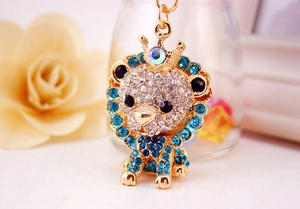 Macro shot of gold lion keychain with sparkling rhinestones and crown detail