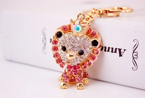 Close-up of sparkling rhinestone lion keychain with pink crystals and gold finish