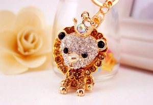 Macro detail of a golden metal lion keychain encrusted with sparkling crystals and gems