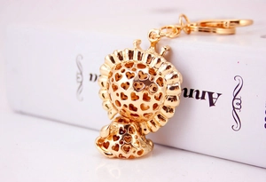 Close-up of golden lion head keychain featuring crown and hollow heart patterns