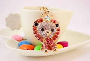 Close-up of pink and clear rhinestones on a golden cartoon lion keychain with crown