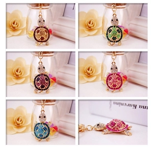 Detail view of five colorful rhinestone sea turtle keychains with golden metal finish
