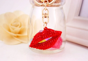 Close-up of red rhinestone encrusted lip keychain with gold-tone metal clasp