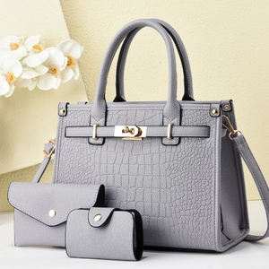 Detailed set of grey crocodile embossed handbags featuring elegant gold metal hardware