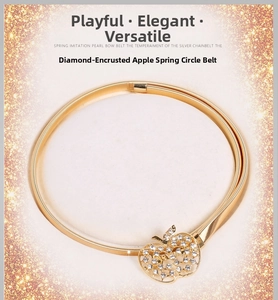 Détail d'une chaîne de taille dorée à ressort avec boucle pomme sertie de strass brillants