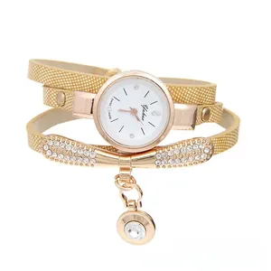 Detail of gold wrap-around bracelet watch with sparkling crystal butterfly and drop charm