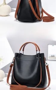 Détails du sac seau en cuir grainé noir avec poignées brunes et bandoulière réglable