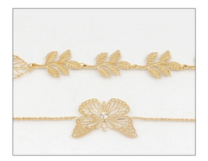 Detailed view of golden leaf chain and butterfly pendant with small crystal accents