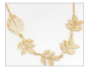 Macro view of a golden hollow leaf hairpiece with delicate tassel chain detailing