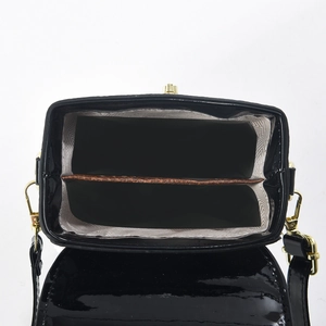 Detailansicht der schwarzen Lackledertasche mit zwei Fächern und goldenem Verschluss
