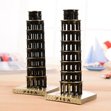 Dettaglio di modellini in metallo vintage della Torre di Pisa su tavolo in legno