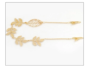 Detailed close-up of golden leaf hair clip with elegant metal texture and chain details