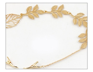 Close-up of a golden leaf hair chain with fine metallic texture and small clips