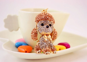 Macro shot of gold-toned poodle keychain with sparkling clear and champagne crystals