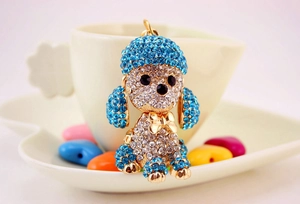 Detailed view of crystal puppy keychain with blue rhinestones and golden bow tie detail