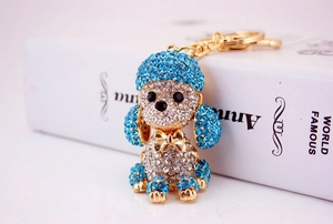 Detailed macro view of a gold poodle keychain decorated with blue and clear crystals