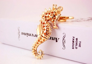 Detailed view of a golden seahorse keychain with sparkling rhinestones and crown detail