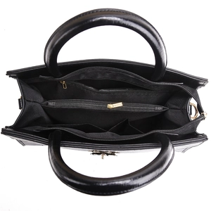 Detailed interior of black leather handbag with multi-layer compartments and gold zippers