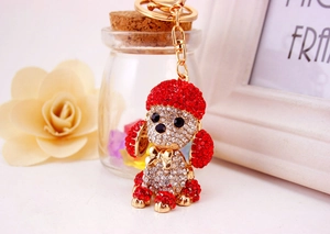Close-up of red and white crystal poodle keychain with golden hardware on a decorative desk