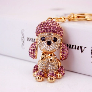Cute golden poodle dog keychain with pink crystals on a white background
