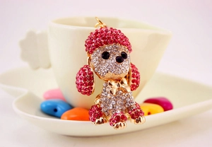 Macro shot of gold poodle keychain with pink and white rhinestones on white background