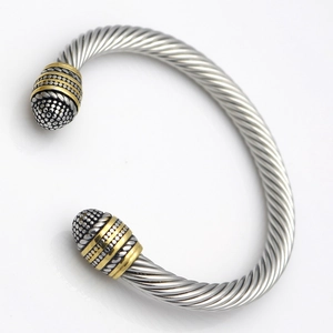 Macro detail of retro two-tone cable bracelet with gold accents and twisted steel texture