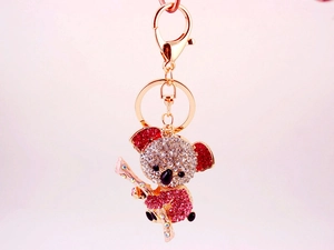 Close-up of sparkling pink and white crystal rhinestones on a gold-plated koala keychain