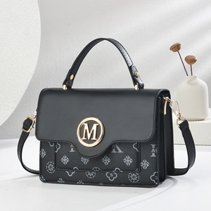 Close-up of black PU leather handbag featuring gold M metal logo and floral pattern print