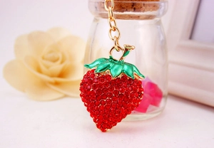 Detailed view of the sparkling red rhinestone strawberry keychain with gold hardware