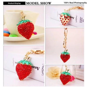 Detail shots of strawberry keychain with red rhinestones and golden lobster clasp
