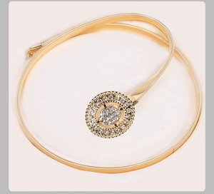 Détail de la ceinture dorée à ressort métallique avec boucle ovale ornée de strass