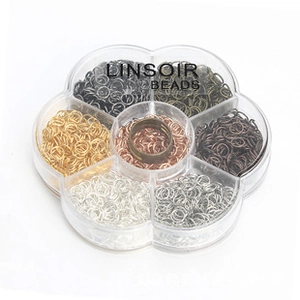Detail of multi-colored jump rings in a floral plastic storage box for jewelry making