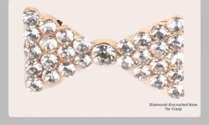 Vue macro d'une boucle noeud en or rose ornée de strass et d'un cristal central brillant
