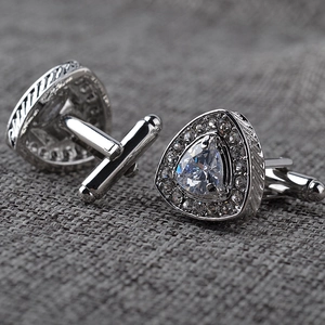 Macro shot of silver triangle cufflinks with crystal inlay and twisted cable edge detail