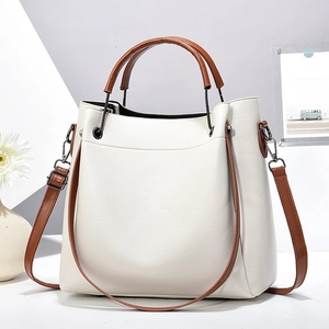Sac seau chic en cuir grainé beige avec poignées brunes et bandoulière réglable