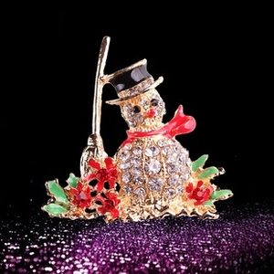 Détail de la broche bonhomme de neige avec strass blancs et écharpe émaillée