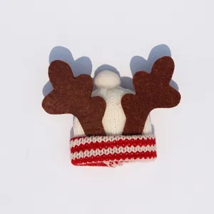 Knitted reindeer hat with white pom-pom and red-white striped brim for Christmas party