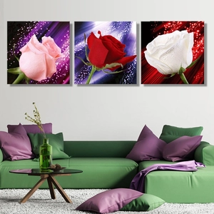 Detailed view of three-piece canvas wall art featuring roses with dew drops above a sofa