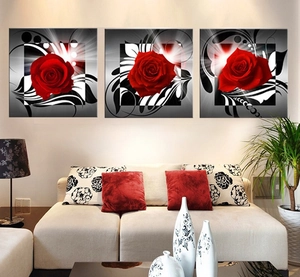 Three-piece wall art set featuring red roses and abstract patterns on a living room wall