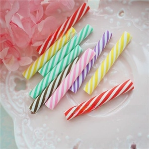 Close-up of colorful striped clay canes for DIY crafts on a decorative ceramic plate