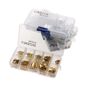 Close-up of DIY jewelry findings set with gold and silver jump rings in clear storage boxes