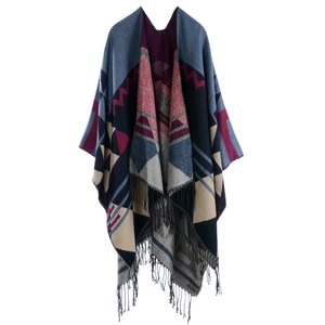 Detail of knit shawl featuring geometric patterns and fringe hem in navy and burgundy