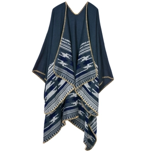 Close-up of deep blue knitted poncho showing geometric texture and yellow edge stitching